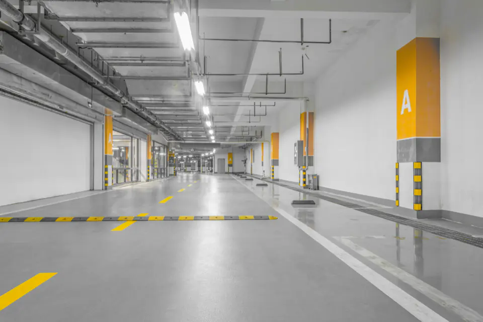 Sarı şerit ve kolon işaretleri olan boş kapalı otopark koridoru